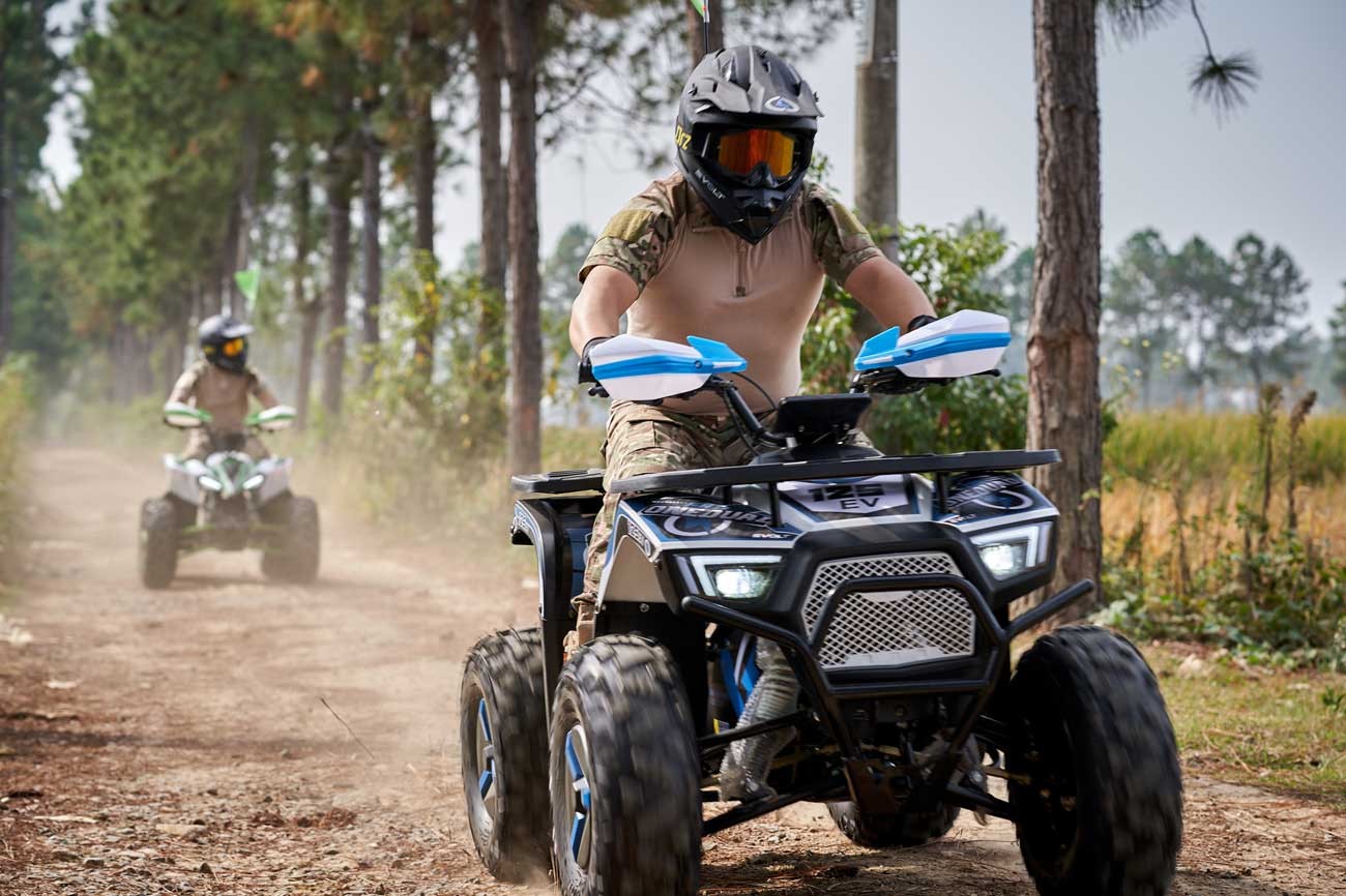 Gasoline ATV riding through off-road trail terrain, representative of the ATV dealer program
