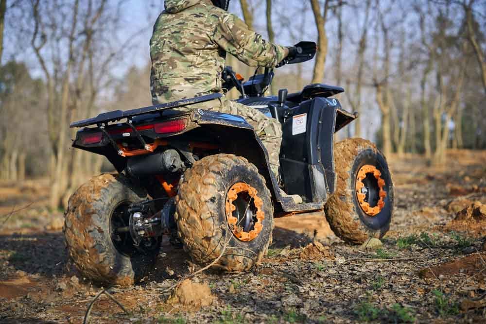 Front end detail of the 180cc utility ATV showing independent double shock absorber suspension and front disc brake